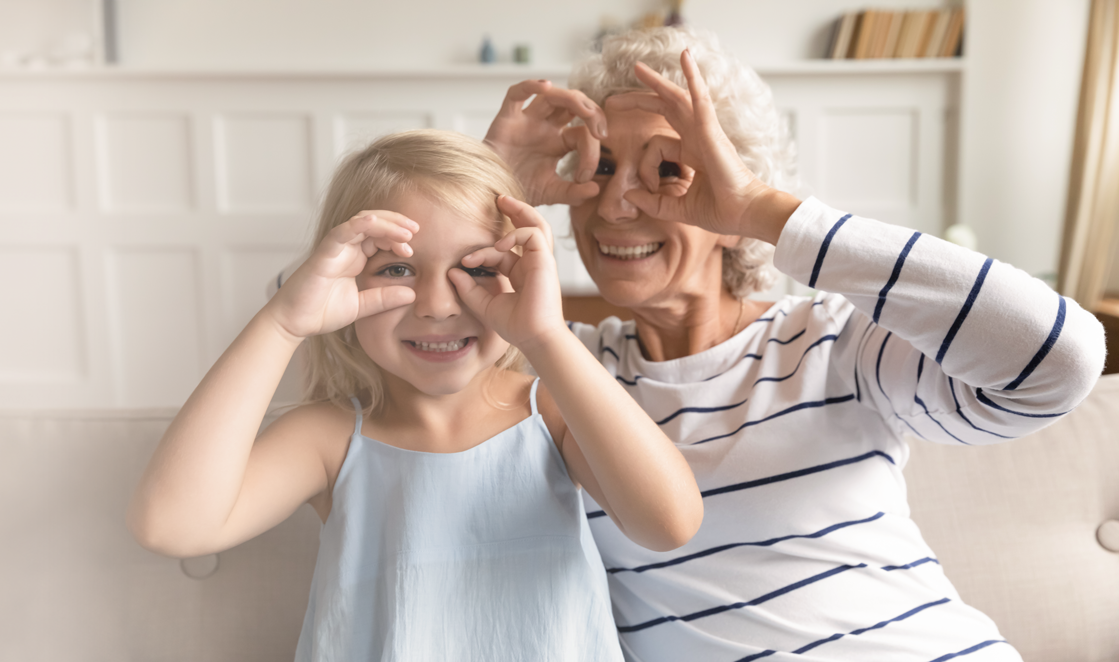 an old lady and young girl making circles around their eyes as if their fingers were glasses for cataracts surgery